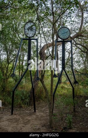 Strana arte in giardino, pipa figure umane con quadrante orologio. Quinta Mazatlan World Birding Center. McAllen, Texas, Stati Uniti. Foto Stock