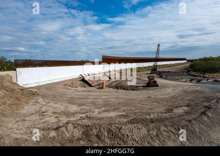 Il muro di confine in acciaio e cemento USA-Messico in costruzione lungo il Rio Grande. McAllen, Texas, Stati Uniti. Foto Stock
