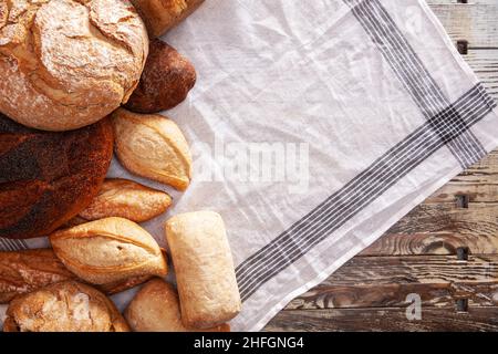 Pane fresco disposto su un tavolo di legno Foto Stock