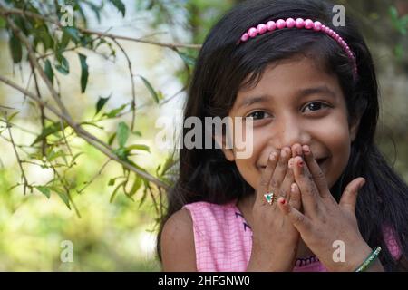 Una ragazza bella che guarda in macchina fotografica e sorridente - concetto di educazione della ragazza Foto Stock