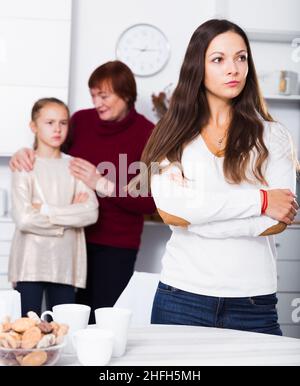 Madre sconvolta dopo litigare con figlia in piedi dietro con nonna Foto Stock