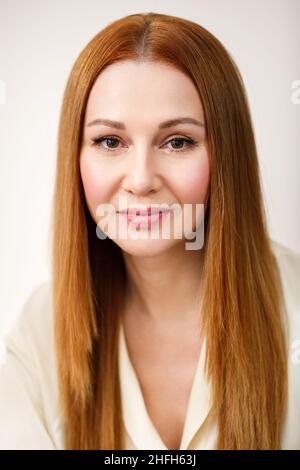 Ritratto di una donna adulta. La donna guarda la macchina fotografica e sorride. Foto Stock