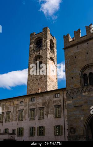 La torre Campanone, dietro le mura di Palazzo del Podestà, vista da Piazza Duomo. A destra il Palazzo della ragione. Foto Stock