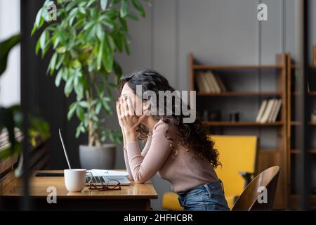 Deluso lavoratore di ufficio femminile che lotta con il compito, stanco lavoratore di lavoro femminile Foto Stock
