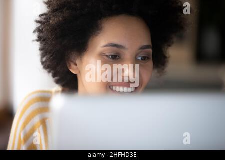 Primo piano sorridente giovane dipendente afroamericano che lavora al computer. Foto Stock