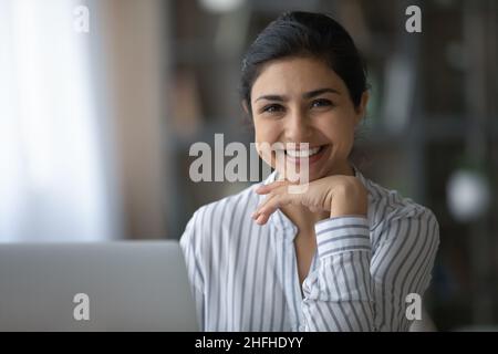 Ritratto di graziosa donna d'affari indiana seduta al tavolo. Foto Stock