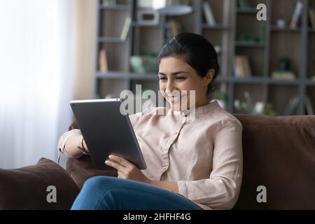 Felice giovane donna indiana con tablet digitale. Foto Stock