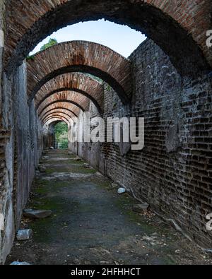 Un sentiero panoramico e antico con archi nel parco archeologico di Baiae vicino Napoli, Campania, Italia Foto Stock