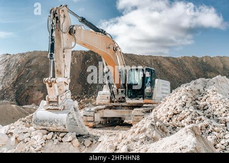 Escavatore Caterpillar con benna grande in cantiere o in cava. Dettagli sui macchinari per attività minerarie pesanti. Movimento terra, scavi, scavando su suoli. Foto Stock