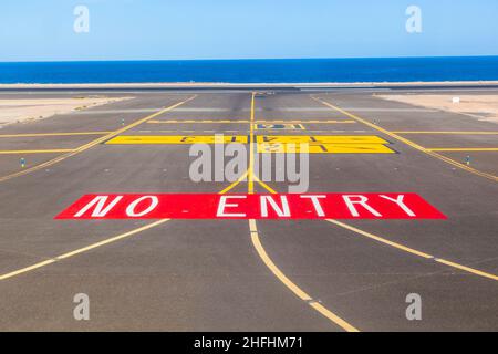 nessun cartello d'ingresso sulla pista dell'aeroporto con l'oceano sullo sfondo Foto Stock