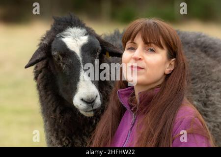 La pastorella Vegan. Immagini di una donna nel nord della Scozia che si prende cura di un piccolo gregge di pecore, molte delle quali hanno problemi di età e salute. Foto Stock