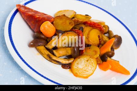 Patate spagnole fritte con funghi e chorizo salsiccia Foto Stock