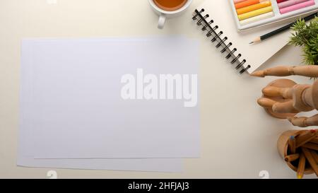 Una pagina vuota di carta sullo spazio di lavoro con cancelleria, pastello di petrolio e decorazione. Area di lavoro per bambini. Foto Stock