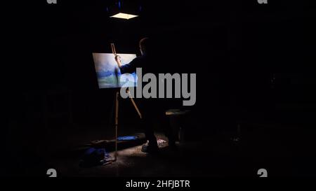 Artista copista paint seascape con nave in oceano. Artigiano arredatore disegnare come barca vela sul mare blu. Sfondo nero. Ampio angolo di ripresa. Foto Stock