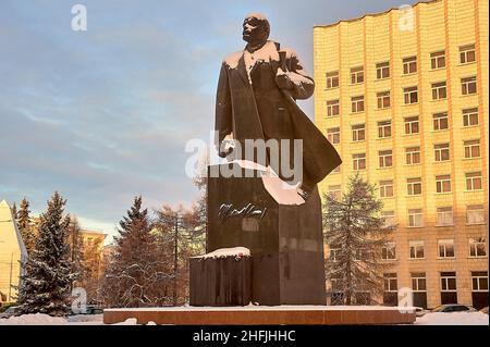 Monumento di Vladimir Lenin sullo sfondo della città polverata di neve in inverno Foto Stock