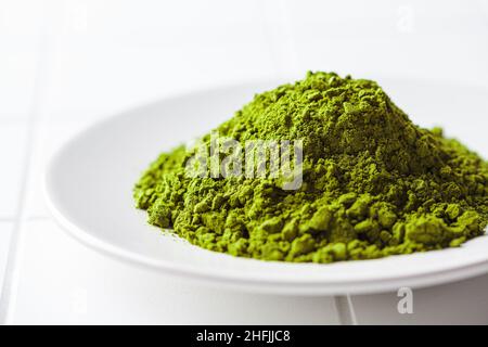 Polvere di tè verde Matcha su un piatto bianco, primo piano. Tradizionale drink giapponese. Foto Stock