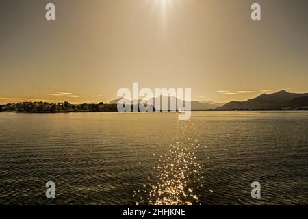 Vista sul Chiemsee con una barca a vela al tramonto Foto Stock