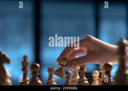 Mano pedina mobile figura sulla scacchiera portatile, sfondo bianco,  effetto di sfocatura Foto stock - Alamy