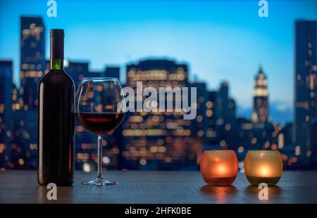 Romantica degustazione di vini rossi con candele e skyline della città di notte Foto Stock