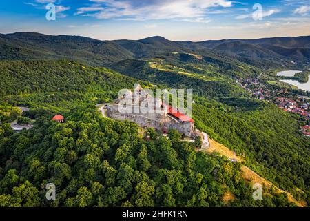 Visegrad, Ungheria - veduta aerea panoramica del bellissimo castello alto di Visegrad con alberi e vegetazione estiva e cielo blu con nuvole a bac Foto Stock