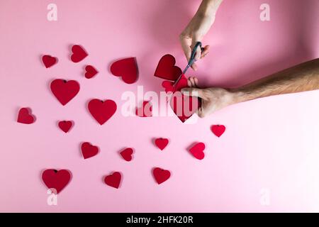 Guy prepara il cuore rosso con carta per giorno valentine Foto Stock