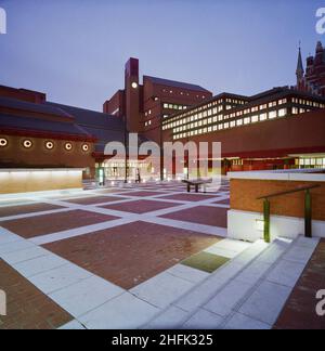 British Library, Euston Road, St Pancras, Camden, Londra, 15/02/1996. La British Library prese dal cortile anteriore al crepuscolo con tutte le luci all'interno dell'edificio. Laing Management Contracting sono stati nominati dalla Property Services Agency per costruire il complesso presso la British Library e la costruzione è iniziata nel luglio 1984. Alla fine il progetto aveva un budget di &#XA3;496 milioni ed è stato completato nel novembre 1995. La British Library è stata aperta al pubblico nel novembre 1997 ed è stata ufficialmente aperta dalla Regina nel giugno 1998. Il sito ha riunito una collezione ospitata attraverso vari si Foto Stock