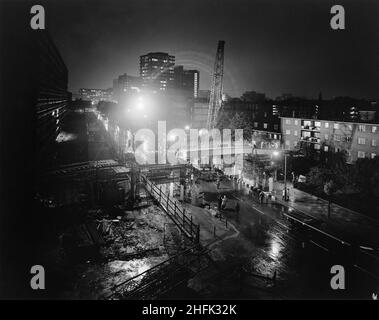 New Kent Road, Newington, Southwark, Londra, 12/06/1973. Una gru Gargantua da 60 tonnellate che abbassa la sezione centrale del ponte durante la costruzione di un ponte pedonale su New Kent Road, Southwark. La polizia ha chiuso la strada dalle 8pm del 12th giugno 1973 fino alle 5,30am del 13th per consentire alla divisione della regione meridionale di Laing di costruire il ponte pedonale. Collegava la tenuta Heygate degli appartamenti Jespersen al lato nord della strada. La trave in calcestruzzo a sezione centrale era lunga 14m tonnellate e pesava 30 tonnellate, la più grande unità singola prodotta dalla fabbrica di calcestruzzo John Laing a Andover. Foto Stock