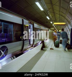 Aeroporto di Heathrow, Heathrow, Hillingdon, Londra, 29/07/1998. Passeggeri che partono da un treno al binario 1 del collegamento ferroviario Heathrow Express. Il collegamento ferroviario Heathrow Express è stato un investimento del &#XA3;350m da parte della British Airport Authority volto ad aumentare dal 34% al 50% la percentuale di passeggeri che viaggiano verso l'aeroporto di Heathrow con i mezzi pubblici. Costruito tra il 1995 e il 1998, nel 2001 trasportava 14.000 passeggeri al giorno prendendo circa 3.000 auto al largo delle strade per migliorare la congestione del traffico. I treni ad alta velocità che partono ogni 15min completano il viaggio dalla stazione di Paddington nel 15min. BA Foto Stock