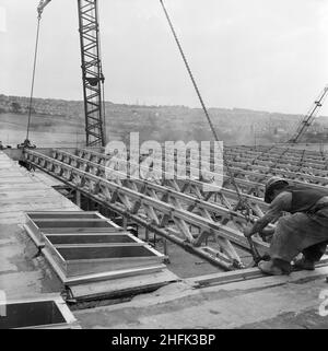 County High School, Gedling Road, Arnold, Gedling, Nottinghamshire, 12/09/1958. Due operai guidano una trave 'Laingspan', abbassata da una gru, in posizione sul tetto di uno dei blocchi della Arnold County High School, durante la sua costruzione. I lavori sono iniziati nel marzo 1958 e la costruzione è stata completata per il nuovo mandato scolastico nel settembre 1959. 'Laingspan' era un sistema modulare flessibile di costruzione di telai che utilizzava unità prefabbricate in calcestruzzo precompresso. Laing ha sviluppato il sistema in collaborazione con il ramo Architetti ed edifici del Ministero dell'Istruzione e Consulenza ingegnere AJ Foto Stock