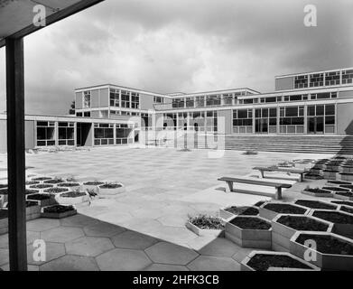 County High School, Gedling Road, Arnold, Gedling, Nottinghamshire, 29/07/1959. Il cortile principale della Arnold County High School visto dall'angolo sud-est, che mostra pavimentazione esagonale e aiuole di fiori in primo piano. I lavori sono iniziati nel marzo 1958 e la costruzione è stata completata per il nuovo mandato scolastico nel settembre 1959. La scuola di grammatica coeducativa ha ospitato 720 alunni. A metà 1960s un'altra scuola è stata costruita nelle vicinanze e nel 1974 i due sono stati amalgamati in un completo. Gli edifici scolastici costruiti a Laing furono infine demoliti nel 2017. Foto Stock