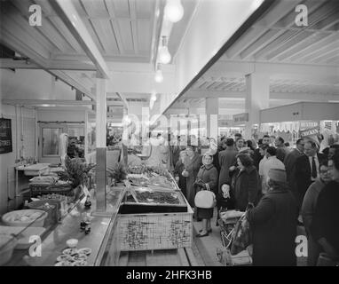 Bull Ring Centre, Birmingham, 14/11/1963. Il mercato del pesce al Bull Ring Center è pieno di negozi il giorno dell'apertura al pubblico. Il 14th novembre 1963, il mercato al dettaglio dello sviluppo di Bull Ring è stato aperto dal Signore Sindaco di Birmingham, Alderman Dr. Louis Glass, JP. Il nuovo mercato al dettaglio sostituì il vecchio edificio del Market Hall, originariamente costruito nel 1835, ma aveva subito gravi danni a causa di un attacco aereo nella seconda guerra mondiale. La sezione generale del nuovo mercato ospitava 154 bancarelle, con altre 42 nella sezione separata del pesce e del pollame. Foto Stock