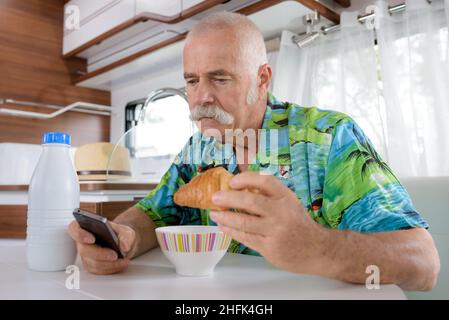 buon uomo anziano che fa colazione Foto Stock