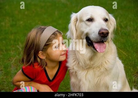 Piccola bambina di otto anni con il suo cane Golden Retriever Foto Stock
