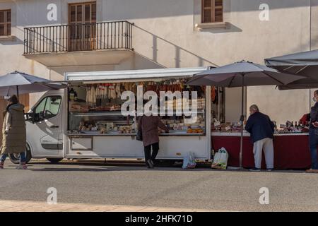 Campos, Spagna; gennaio 15 2022: Mercato settimanale di strada nella città di Majorcan di Campos. Fornitori e clienti con maschere a causa di restrizioni da parte di Omicr Foto Stock