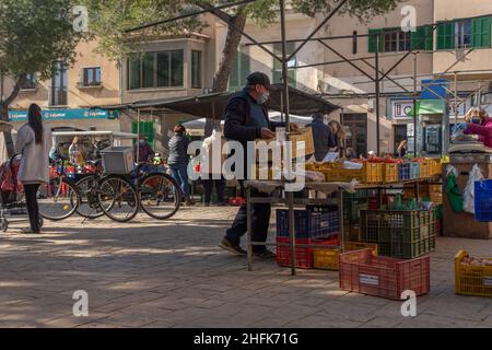 Campos, Spagna; gennaio 15 2022: Mercato settimanale di strada nella città di Majorcan di Campos. Fornitori e clienti con maschere a causa di restrizioni da parte di Omicr Foto Stock