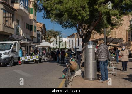 Campos, Spagna; gennaio 15 2022: Mercato settimanale di strada nella città di Majorcan di Campos. Fornitori e clienti con maschere a causa di restrizioni da parte di Omicr Foto Stock