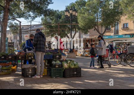 Campos, Spagna; gennaio 15 2022: Mercato settimanale di strada nella città di Majorcan di Campos. Fornitori e clienti con maschere a causa di restrizioni da parte di Omicr Foto Stock