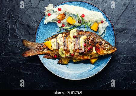 Carpa di pesce al forno con frutta, bacche e spezie. Mangiare sano Foto Stock