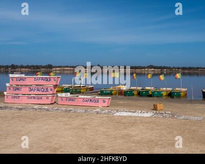 Lac Rose, Senegal - Febbraio 2019: Barche di legno con bandiera senegalese sulla riva del lago di Reba. Africa Foto Stock