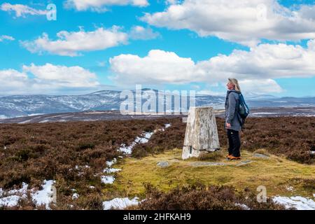 Un camminatore alla cima del cairn su Lord Arthur's Hill nelle colline di Correen vicino ad Alford, Aberdeenshire, Scozia Foto Stock
