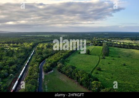 Aereo di un treno merci generale che passa il villaggio di Yandaran Queensland Australia Foto Stock