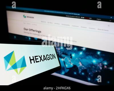 Smartphone con logo della società software svedese Hexagon AB sullo schermo di fronte al sito Web aziendale. Concentratevi sul centro-destra del display del telefono. Foto Stock