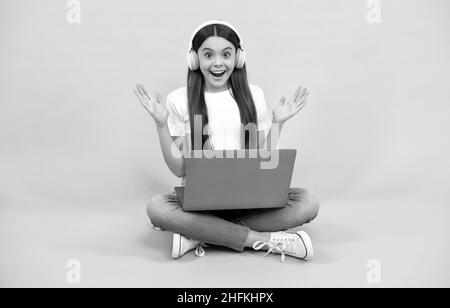 ragazza sorpresa acquistare online. torna a scuola. teen influencer blogging. webinar in cuffia wireless Foto Stock