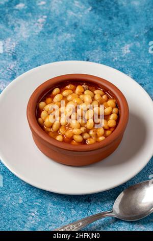 Stufato di fagiolo turco caldo su sfondo blu. Fagioli di Ispir cotti in una casseruola - Kuru Fasulye Foto Stock