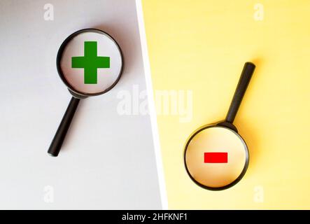 Il concetto di opposti, più e meno, disposizione piatta. Figure di legno più e meno su uno sfondo di legno. Più contro meno con spazio di copia, vista dall'alto. Foto Stock