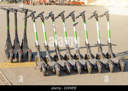 Scooter elettrici parcheggiati sulla strada della città. Servizio self-service di noleggio di mezzi di trasporto su strada Foto Stock