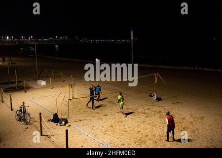 La gente gioca a Beach volley di notte nella spiaggia di Barceloneta a Barcellona, in Spagna, il 13 gennaio 2022. Una sorta di vita normale è tornata in Spagna grazie ad un elevato tasso di vaccinazione contro il Covid-19, anche se sono state imposte nuove restrizioni per frenare la diffusione della variante Omicron. (Foto di Davide Bonaldo/Sipa USA) Foto Stock