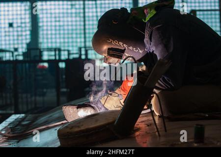 Saldatrice in lavoro. Primo piano. Titolo sulla maschera: Uralsk. Città di Uralsk, Kazakistan. Foto Stock