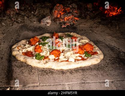 Pizza rustica a legna nel forno per pizza Foto Stock