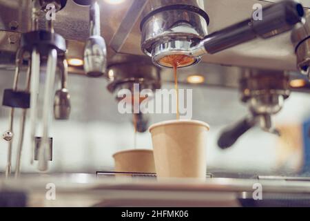 Macchina da caffè professionale con caffè espresso in caffè Foto Stock